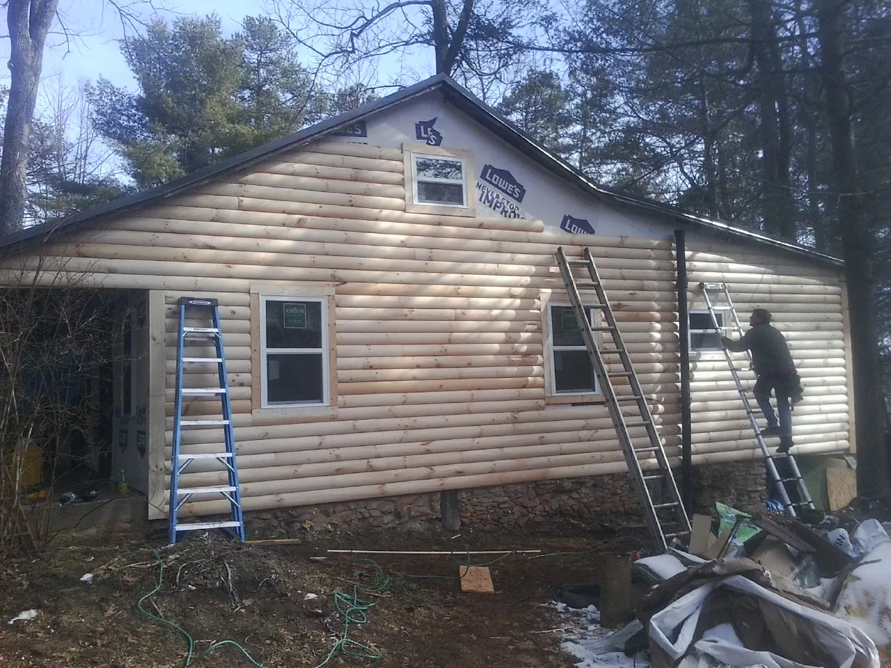 Ladders set against fresh log siding during an exterior remodel in Duluth