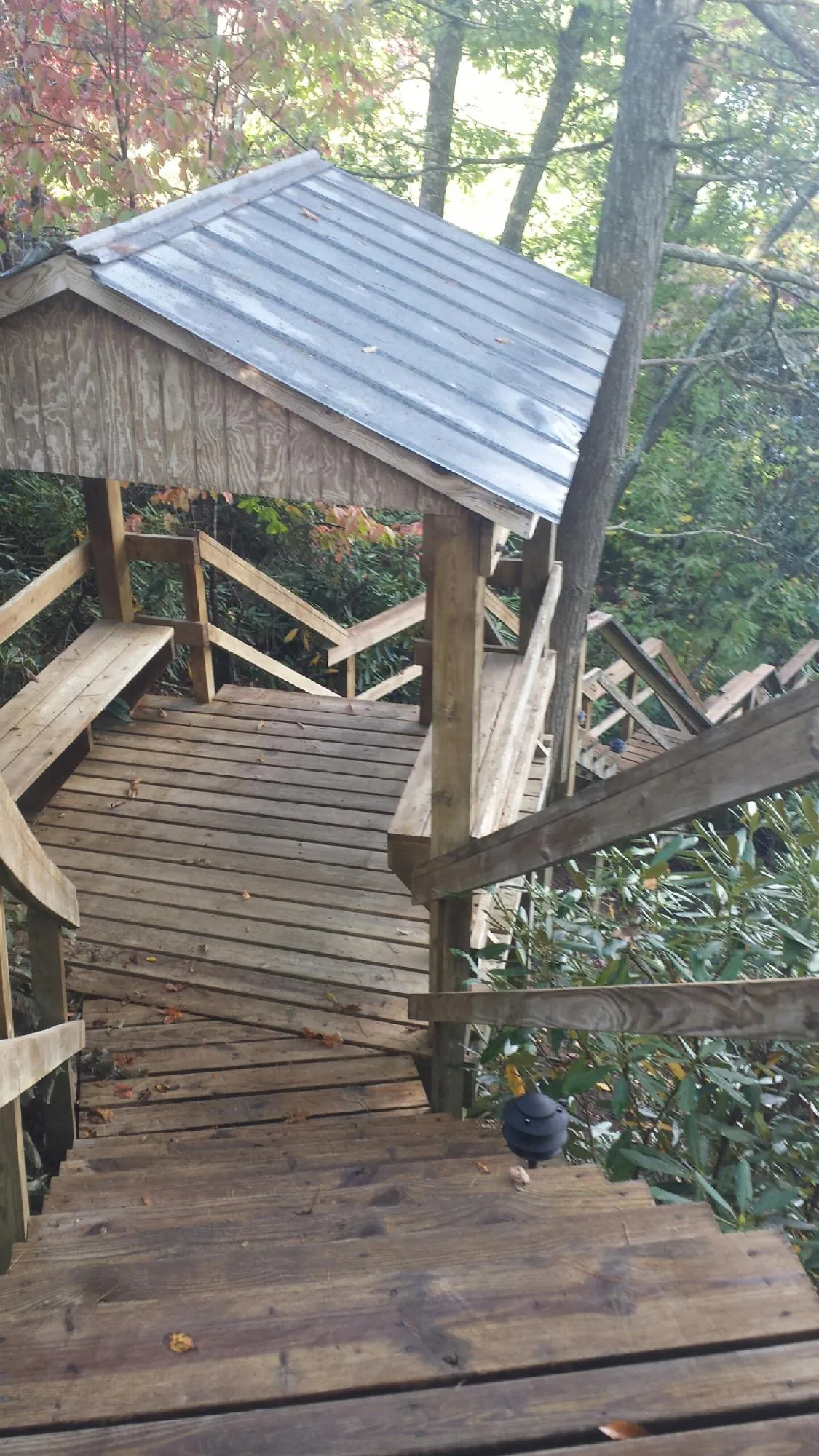 Metal roofed shelter over wooden steps on a wooded walkway — Skylight Repair & Installation work by our crew in Duluth