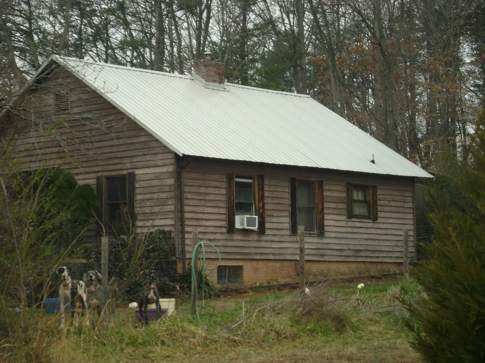 White metal roof on an old wood sided farmhouse, from a Metal Roof Installation job in Duluth